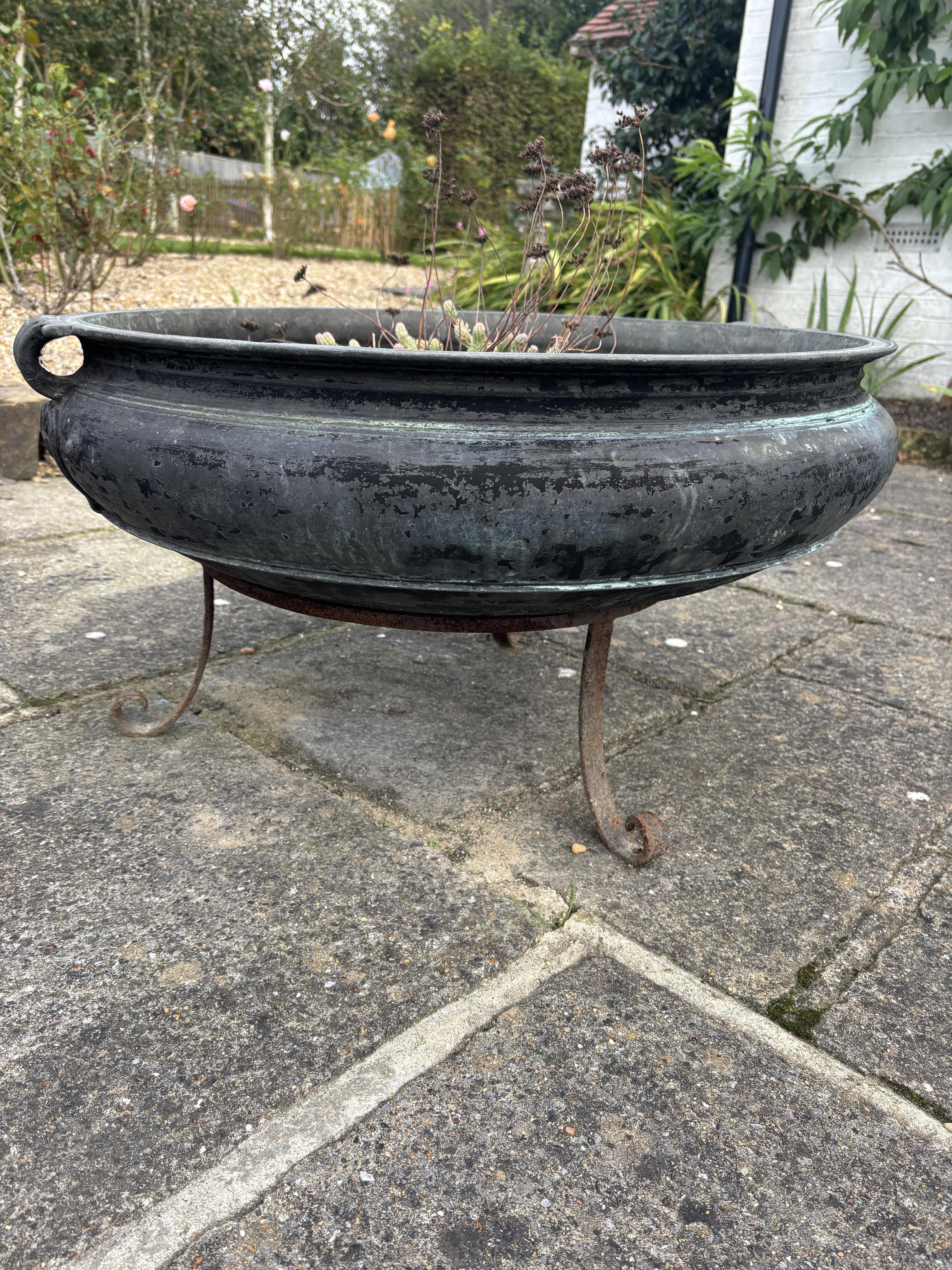 A large Indian bronze incense burner on wrought iron stand, width 79cm, 42cm high overall. one hole drilled. Condition - weathered, otherwise good